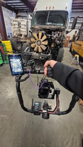 Videographer filming a semi truck engine on a gimbal rig