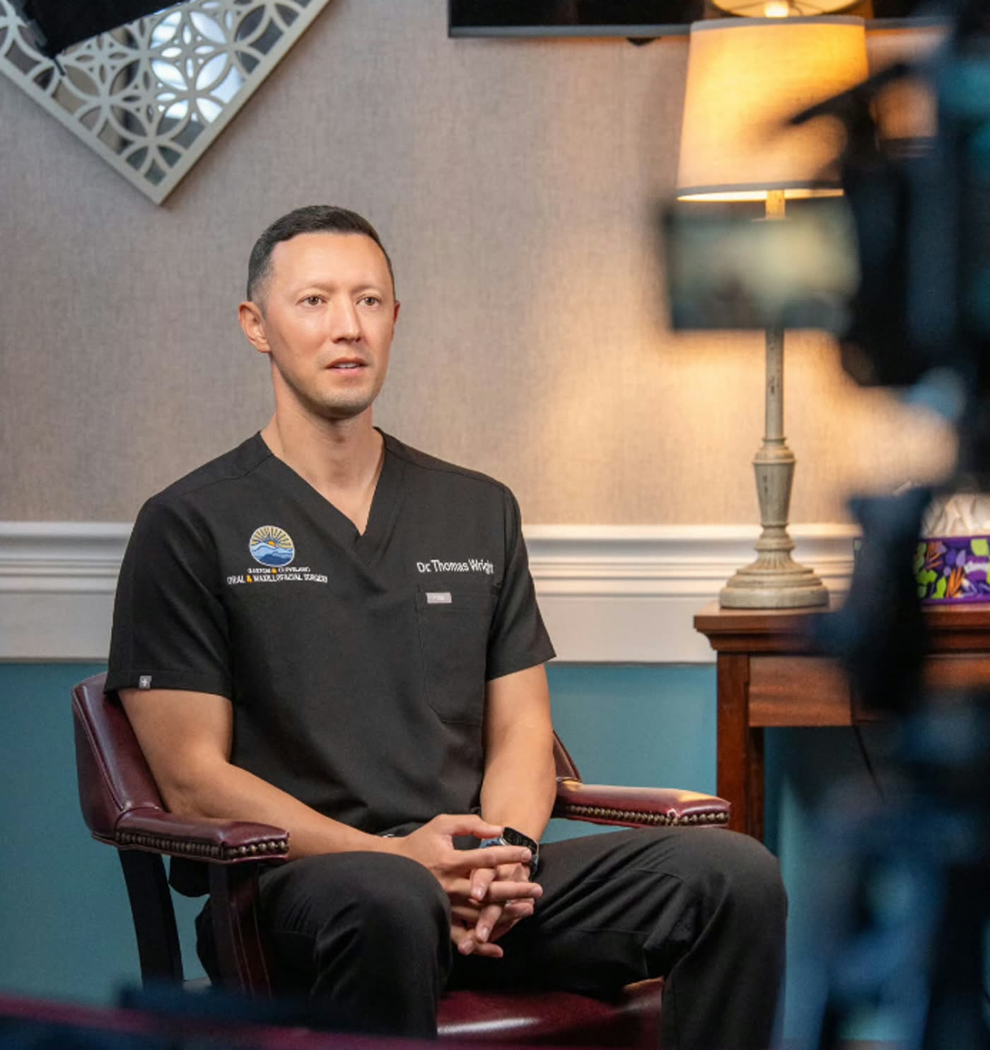 Oral surgeon interviewed on camera inside his practice