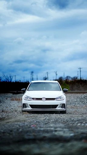 White Volkswagen Golf GTI photographed on a gravel path