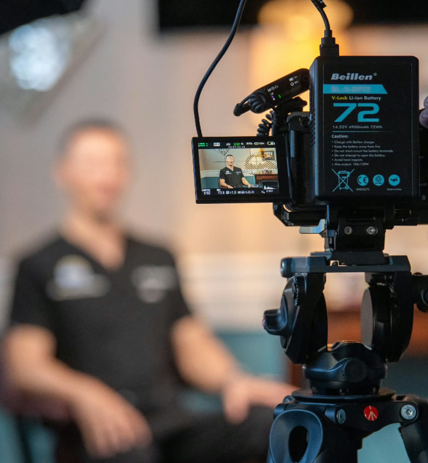 Cinema camera monitor framing a seated interview subject